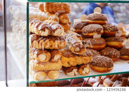 A beautifully arranged assortment of delicious pastries and donuts on display at the bakery A beautifully arranged assortment of delicious pastries and donuts on display at the bakery 123456286