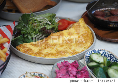 A hearty omelette alongside a vibrant salad and sliced vegetables 123456321