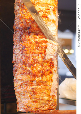 Savory meat being sliced at a street vendor in a bustling city Savory meat being sliced at a street vendor in a bustling city 123456322