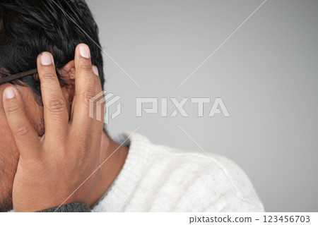 Man covering ears while experiencing loud noise in quiet room Man covering ears while experiencing loud noise in quiet room 123456703