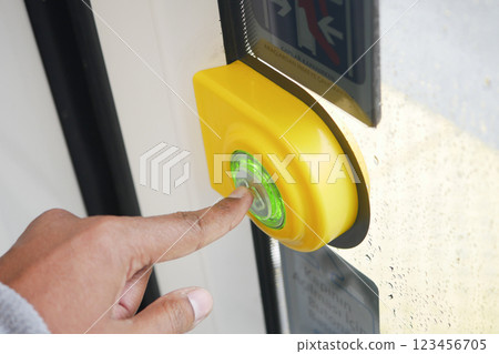 Hand pressing button to open door at modern transit station 123456705