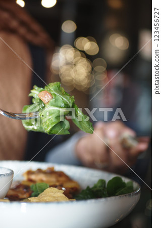 Fresh salad being enjoyed at a cozy restaurant setting during dinner Fresh salad being enjoyed at a cozy restaurant setting during dinner 123456727
