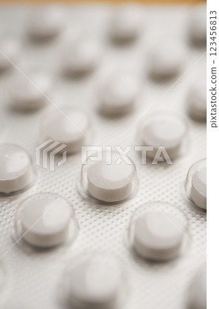 Close-up view of white medication tablets in a blister pack 123456813