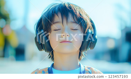 Boy listening to music with headphones with eyes closed 123457193