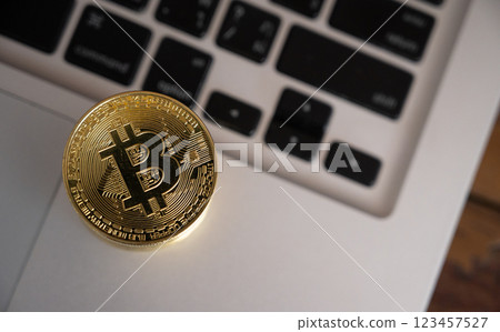 A Bitcoin token on computer keyboard. 123457527