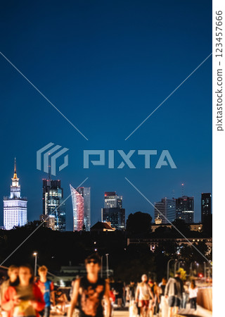 night over skyline of Warsaw city with skyscrapers and downtown district, crowd of people walking, tourist travel destination, rush hour in capital of Poland 123457666