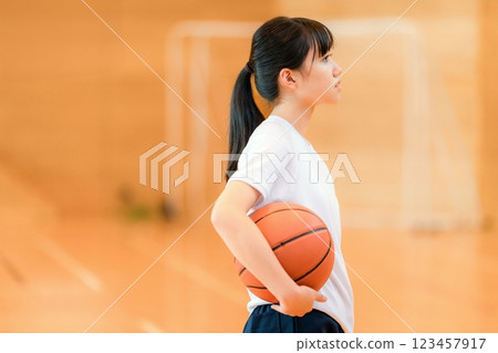 Female junior high school students and high school students wearing gym clothes holding basketballs in a gymnasium 123457917