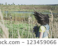 Half turn woman with flying hair in blooming lavender field looking at sunset. 123459066