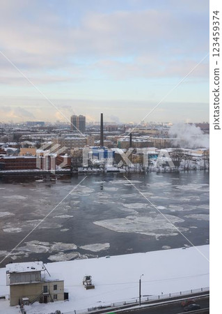 A stunning winter cityscape featuring a frozen river alongside a striking industrial skyline 123459374