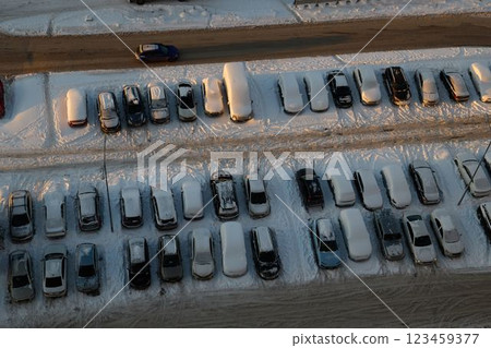 An Aerial View Capturing a SnowCovered Parking Lot Featuring Various Vehicles Positioned An Aerial View Capturing a SnowCovered Parking Lot Featuring Various Vehicles Positioned 123459377