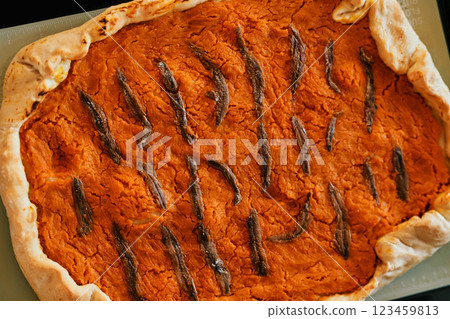 Pumpkin pie with anchovies lies on a baking sheet. Top view Pumpkin pie with anchovies lies on a baking sheet. Top view 123459813