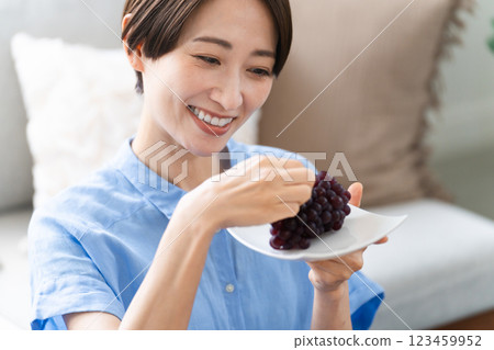 Young woman eating grapes lifestyle image Young woman eating grapes lifestyle image 123459952