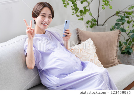 Pregnant woman operating a smartphone Lifestyle image 123459985