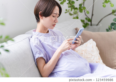 Pregnant woman operating a smartphone Lifestyle image 123459986