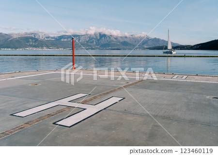 Helipad on the pier by the sea against the backdrop of mountains Helipad on the pier by the sea against the backdrop of mountains 123460119