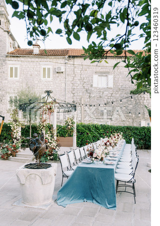 Laid long table with chairs stands in the garden near the wedding rotunda 123460319