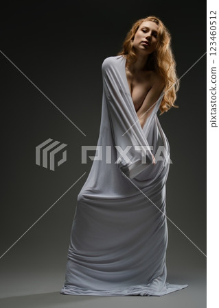 Beautiful woman in sensual lingerie pose with flowing fabric in soft light 123460512