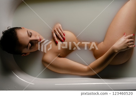 Woman in a bath embracing beauty and body art while relaxing in serene waters Woman in a bath embracing beauty and body art while relaxing in serene waters 123460520
