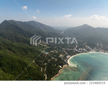 Small town nestled between lush green hills and turquoise ocean waters, with roads and beaches visible. Ko Pha Ngan, Thailand. Small town nestled between lush green hills and turquoise ocean waters, with roads and beaches visible. Ko Pha Ngan, Thailand. 123460533