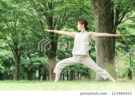 Young Asian woman doing park yoga, yoga, pilates, stretching in forest/park (Warrior pose) Young Asian woman doing park yoga, yoga, pilates, stretching in forest/park (Warrior pose) 123460935