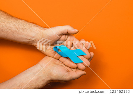 Blue ribbon for cancer awareness on an orange background 123462153