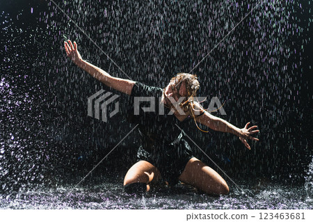 Contemporary woman dancer posing in rain water on black background. Female artist performer dancing with expression. Modern ballerina dancing in darkness. Passion dance in dark. Flexibility balance Contemporary woman dancer posing in rain water on black background. Female artist performer dancing with expression. Modern ballerina dancing in darkness. Passion dance in dark. Flexibility balance 123463681