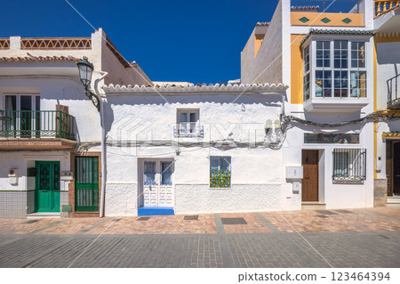 Nerja town, a resort of The Costa del Sol seaside region in Andalusia in the south of Spain. Whitewashed houses line a sunny street, showcasing traditional architecture and vibrant colors. 123464394
