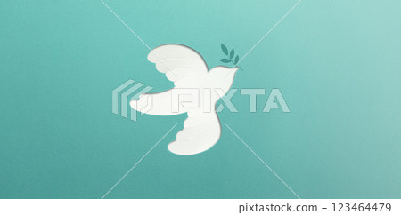 Peace and New Beginnings of Hope. A white dove Flying with an Olive Branch. World International Peace Day. The Concept of a Fluttering Bird that brings Peaceful to the World, Made from Paper Peace and New Beginnings of Hope. A white dove Flying with an Olive Branch. World International Peace Day. The Concept of a Fluttering Bird that brings Peaceful to the World, Made from Paper 123464479