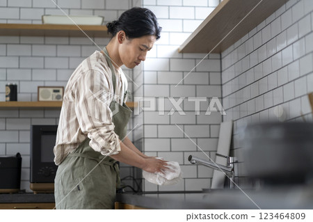 一位 40 多歲男子在廚房洗碗的側面照 一位 40 多歲男子在廚房洗碗的側面照 123464809