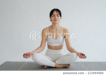 Yoga mindfulness meditation. Healthy woman practicing yoga isolated on white background. Woman sitting in lotus pose meditating relaxing. Girl doing breathing practice. Yoga on white background 123464980