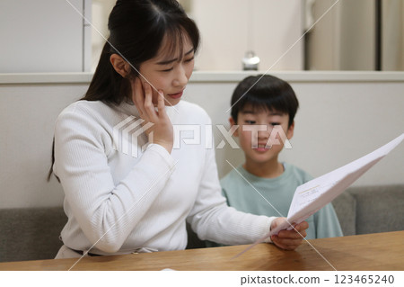 A mother with a troubled face looking at her report card 123465240