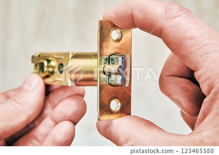 Closeup new tubular door latch in human hands before installation. 123465388