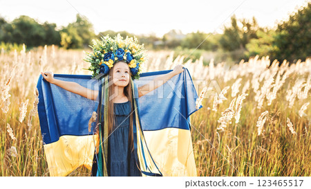 Girl blue and yellow flag of Ukraine in field. Ukraine's Independence Flag Day. Constitution day. 24 August. Patriotic holiday. Girl blue and yellow flag of Ukraine in field. Ukraine's Independence Flag Day. Constitution day. 24 August. Patriotic holiday. 123465517