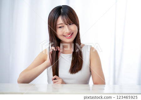 Young woman combing her hair with her hands Young woman combing her hair with her hands 123465925