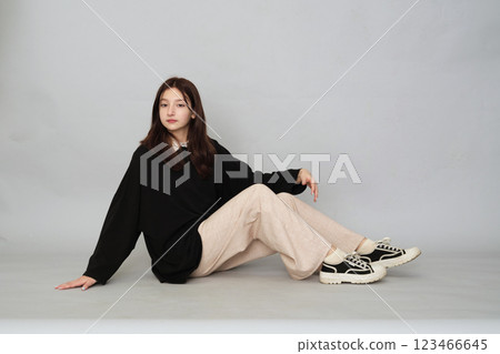 Young girl posing in a versatile black hoodie, a staple for any casual or streetwear-inspired teen wardrobe. 123466645