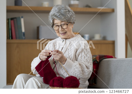 一位 80 多歲的婦女正在編織 一位 80 多歲的婦女正在編織 123466727