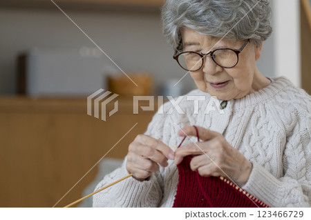 A woman in her 80s knitting 123466729