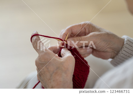 The hands of an 80-year-old woman knitting 123466731