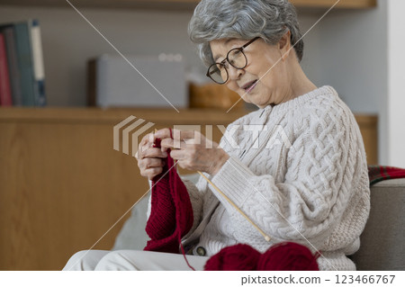 A woman in her 80s knitting 123466767