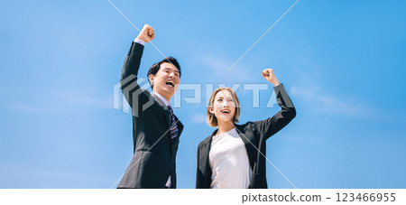 Two smiling businessmen, male and female, making a fist pump Two smiling businessmen, male and female, making a fist pump 123466955