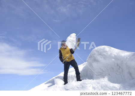 An old man clearing a pile of snow with a shovel 123467772