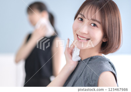 Young woman wiping sweat with a towel 123467986