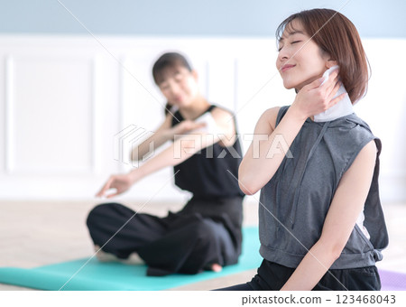 Young woman wiping sweat with a towel Young woman wiping sweat with a towel 123468043