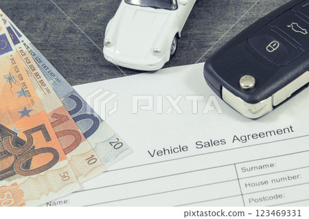 White toy car, car key, euro banknotes and vehicle sales agreement White toy car, car key, euro banknotes and vehicle sales agreement 123469331