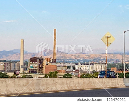 Industrial Landscape With Smokestacks with the Rocky Mountains in the Background During Clear Weather Industrial Landscape With Smokestacks with the Rocky Mountains in the Background During Clear Weather 123470031