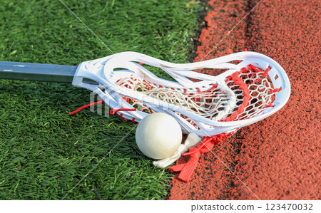 Lacrosse Stick and Ball on Artificial Turf Near a Track at a Sports Facility Lacrosse Stick and Ball on Artificial Turf Near a Track at a Sports Facility 123470032