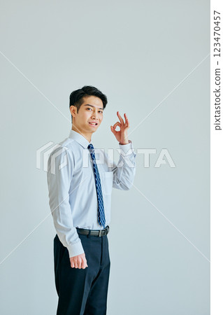 A young man in a dress shirt making an OK pose 123470457