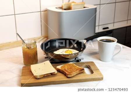 Breakfast served on the kitchen table with a fried egg on a plate and fresh bread and coffee 123470493