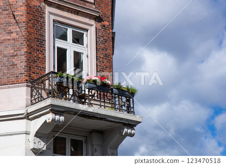 Cute old balcony with flowers and a window in an old blick house. Cute old balcony with flowers and a window in an old blick house. 123470518