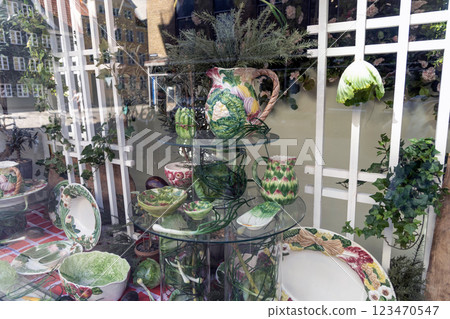 Shop window with a set of dishes with ornaments of vegetables. 123470547